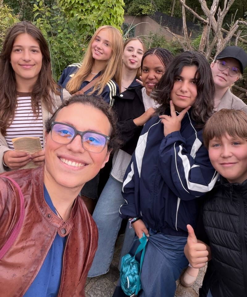Schloss Krumbach International School students pose for a group selfie surrounded by greenery at Schönbrunn Zoo.