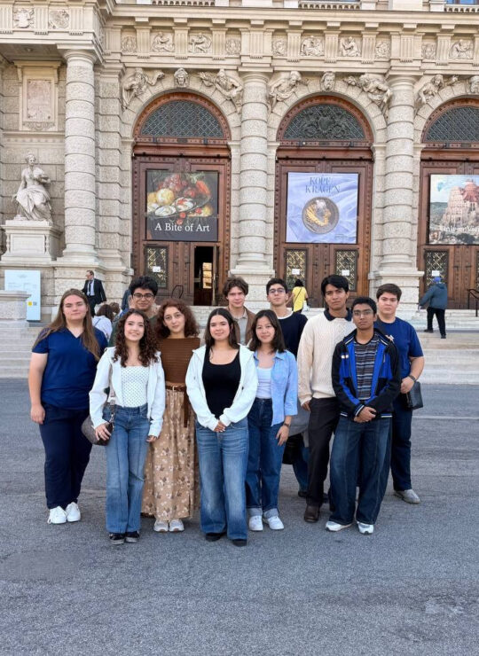 Our school group poses together outside the museum, framed by its decorated stone façade and tall arched windows.