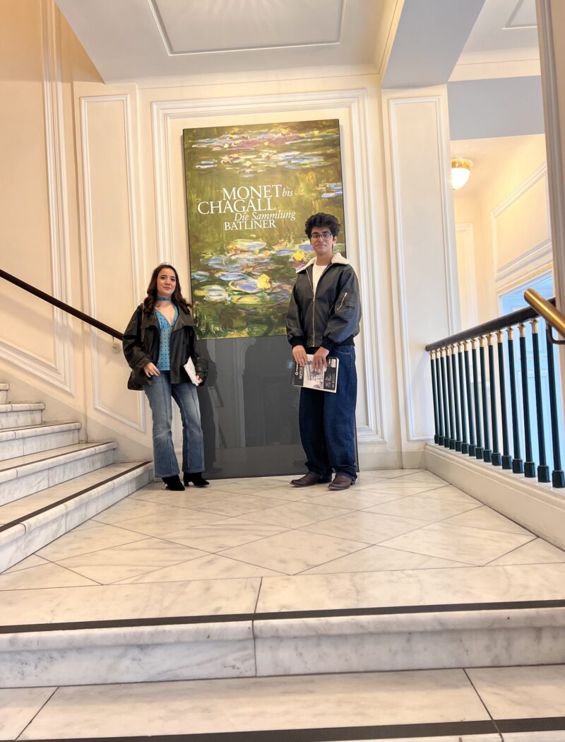 Two Schloss Krumbach International School students standing on the colorful Picasso and Bacon exhibition staircase outside Vienna's Albertina Museum.