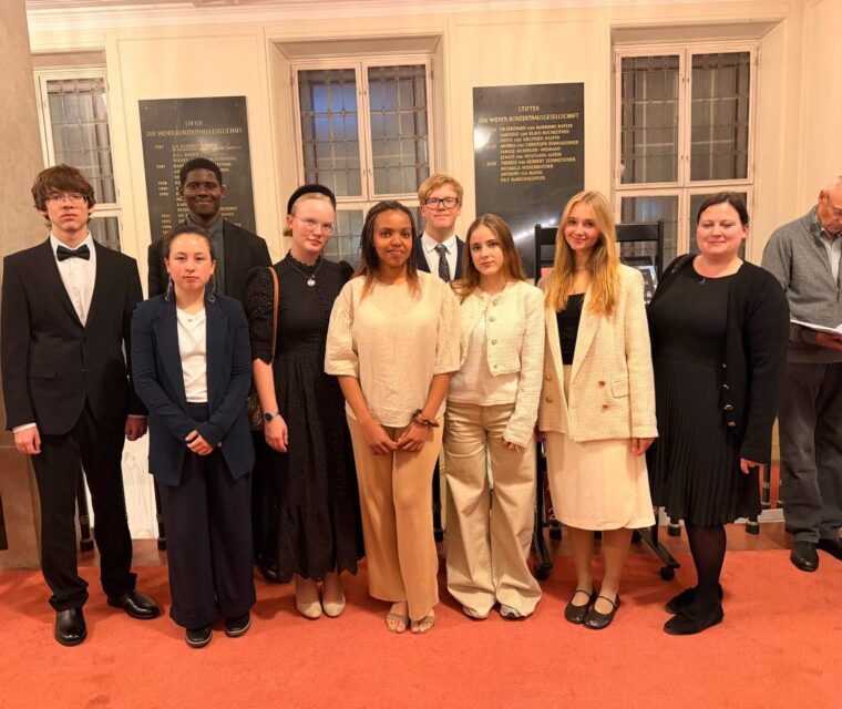 Schloss Krumbach International School students and an accompanying teacher posing for a group photograph inside the Wiener Konzerthaus.
