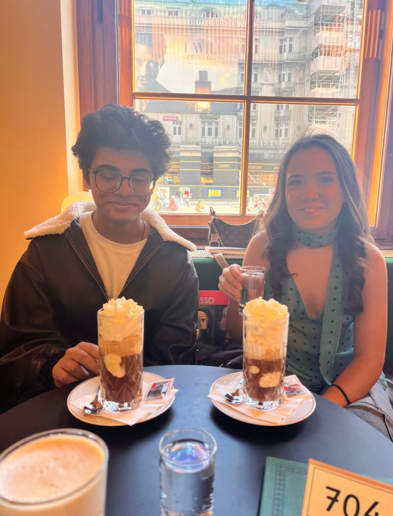 Two Schloss Krumbach International School students enjoying hot chocolate at a café in Vienna after their Albertina Museum visit.